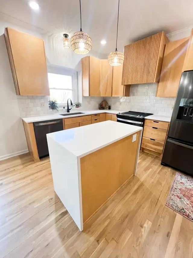 Lee's Summit kitchen with maple cabinets, white island and woven pendant lights over a wood floor