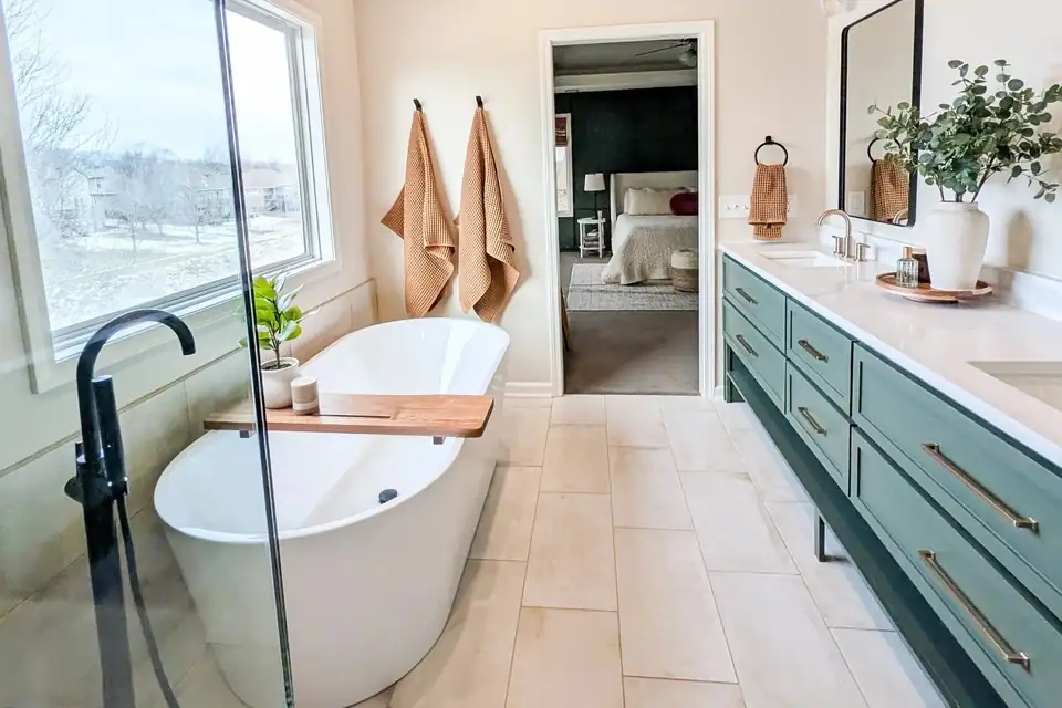 Bathroom remodeling Lee's Summit project: spa-style primary bath with freestanding tub, sage green double vanity and wood-look tile floor