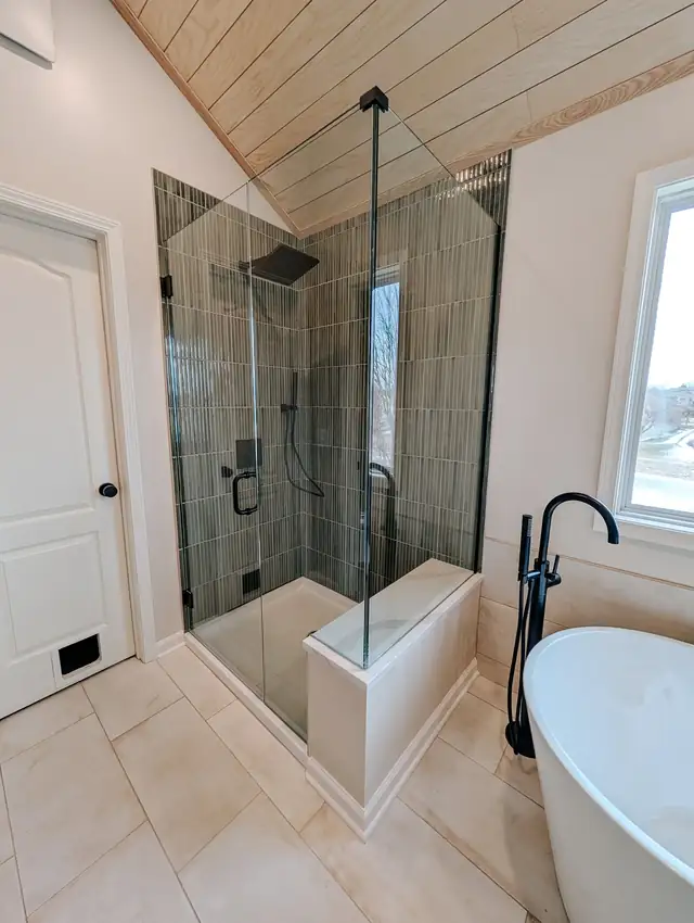 Lee's Summit primary bathroom with frameless glass shower, freestanding tub and tongue-and-groove wood ceiling