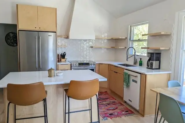 Lee's Summit kitchen remodel with natural maple cabinets, white island, leather counter stools and open wood shelves